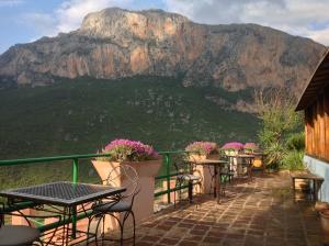a balcony with tables and chairs with a mountain in the background at Caiat Lounge Refuge in Taghzoute