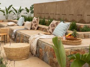 a patio with several pillows and tables and chairs at Little Villa by Ideas Cartel in Hermanus