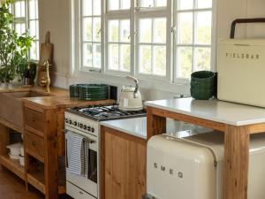 a kitchen with a stove and a refrigerator and windows at Little Villa by Ideas Cartel in Hermanus +9 photos