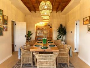 a dining room with a table and wicker chairs at Little Villa by Ideas Cartel in Hermanus