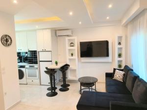 a living room with a couch and a tv on a wall at Chrisella Crystal in Skala Rachoniou