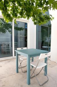 un tavolo blu e due sedie di fronte a un edificio di Beautiful 3 bedroom Villa in Lisbon South Bay ad Almada Altre 69 foto