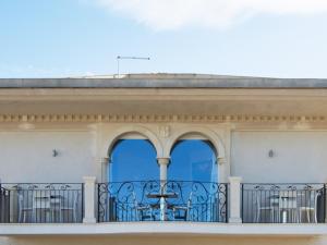 un balcone di un edificio con tre finestre di Ermes ad Avola