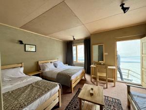 a hotel room with two beds and a window at Bucolic River Resort in Gulmit