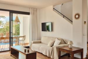 a living room with a couch and a table at Luxe villa met privézwembad - Sant Antoni view - Boho Villas Ibiza in San Antonio Bay