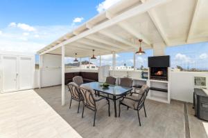 ein Esszimmer mit Tisch und Stühlen und einem Kamin in der Unterkunft Villa dona Isidora - VipVipVillas in Teguise