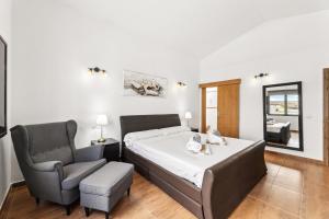 ein Schlafzimmer mit einem Bett und einem Stuhl in der Unterkunft Villa dona Isidora - VipVipVillas in Teguise + 35 Fotos