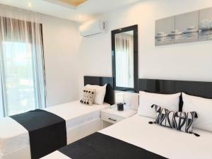 two beds in a room with white and black at Chrisella Crystal in Skala Rachoniou