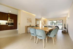 una cucina e una sala da pranzo con tavolo e sedie in legno di Casa Mar Azul - Lux Tavira a Luz de Tavira