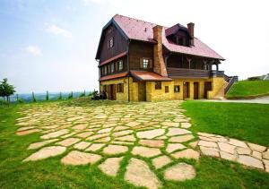 a large house on top of a grassy field at Rooms Bolfan Vinski Vrh in Hrašćina