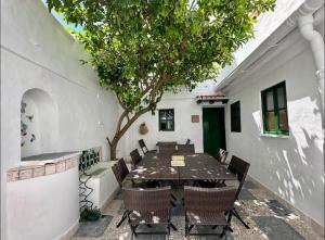 a dining room with a table and chairs and a tree at Espectacular Casa Cordobesa in Córdoba
