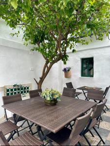 a wooden table with chairs and a tree at Espectacular Casa Cordobesa in Córdoba