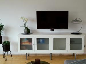 un centro de entretenimiento blanco con TV de pantalla plana. en Mein Schwarzwaldzauber, en St. Blasien
