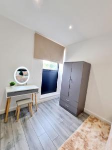 a white room with a desk and a mirror at Woolwich Apartments in London