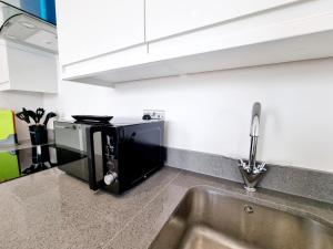 a kitchen with a microwave and a sink at Woolwich Apartments in London +2 photos