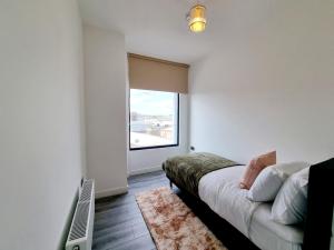 a room with a bed and a large window at Woolwich Apartments in London