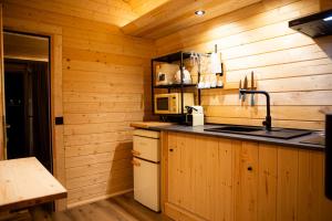 a kitchen with a sink and a microwave in a cabin at Quinta do Prado Verde in Vilar Formoso