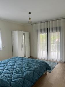 a bedroom with a large blue bed and windows at Casa da Mini in Mondim de Basto
