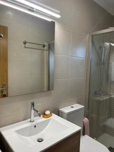 a bathroom with a sink and a shower and a toilet at Casa da Mini in Mondim de Basto