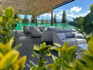 a patio with a bunch of couches and chairs at Domeniul CRIS Vatra Dornei in Vatra Dornei