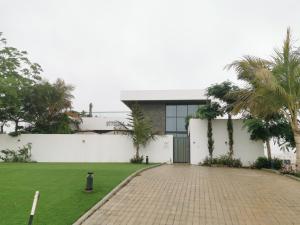 a house with a brick driveway and palm trees at G R A N D C H A L E T in Salalah