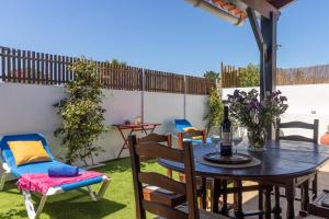 a patio with a table and chairs on the grass at Nest by the Lagoa, Carvalhal in Grândola