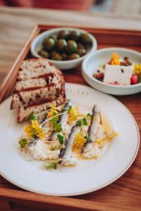 a plate of food with a sandwich and bread on a tray at Ellery Beach House in Lidingö
