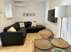 a living room with a black couch and a table at Espectacular Casa Cordobesa in Córdoba