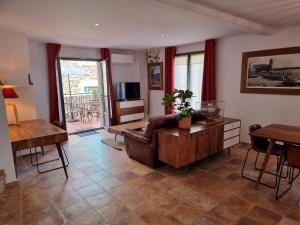 ein Wohnzimmer mit Sofa und Tisch in der Unterkunft Maison T3, quartier des peintres, calme et standing, patio privé, clim et wifi in Collioure