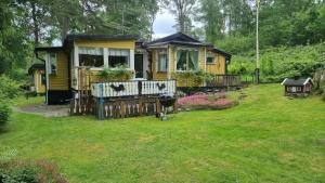 a yellow house with a fence in the yard at Tämta Beach in Fristad