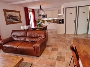 ein Wohnzimmer mit einer Ledercouch und einem Tisch in der Unterkunft Maison T3, quartier des peintres, calme et standing, patio privé, clim et wifi in Collioure