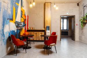a restaurant with red chairs and tables in a room at Отель Авеню in Oral