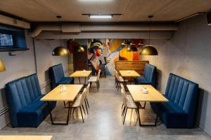 a restaurant with wooden tables and blue chairs at Отель Авеню in Oral