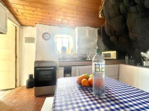 a bottle of water and fruit on a table in a kitchen at Casa Cueva con Vistas Panorámicas al Mar y BBQ in Pozo de las Calcosas +8 photos