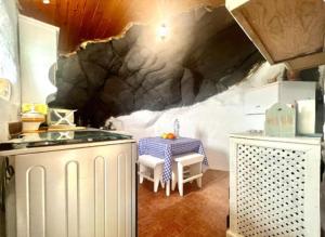 a kitchen with a table and a sink in a room at Casa Cueva con Vistas Panorámicas al Mar y BBQ in Pozo de las Calcosas