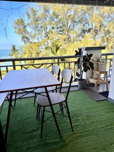 a table and chairs on a balcony with a view of the ocean at Corus Seaview Family Suite at Port Dickson 6-8 pax in Port Dickson