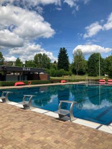 a large swimming pool with blue water at Ferienhaus mit Sauna, Wintergarten und Terrasse im schönen Hochtaunus in Glashütten