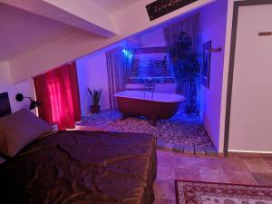 ein Schlafzimmer mit einer Badewanne in einem Raum mit violetten Lichtern in der Unterkunft Maison T3, quartier des peintres, calme et standing, patio privé, clim et wifi in Collioure + 19 Fotos