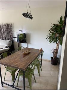 a dining room with a wooden table and green chairs at Habitación individual con baño privado en piso de lujo in San Juan de Aznalfarache