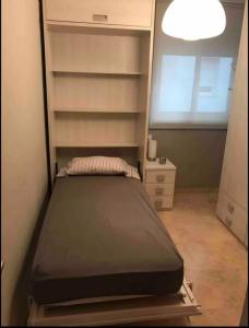 a small bedroom with a bed and a window at Habitación individual con baño privado en piso de lujo in San Juan de Aznalfarache