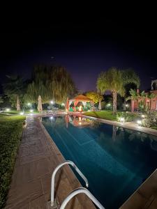 a swimming pool at night with a house at Maison Dar Rima in Aït Ali Ou Allah