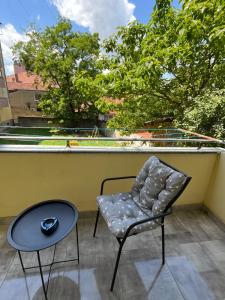 a chair and a table on a balcony at Elite Space in Niš