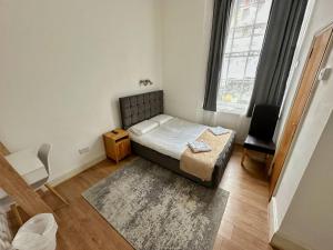 a small bedroom with a bed and a window at Somerset Hotel Baker Street London in London