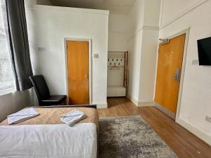 a hotel room with a bed and a chair at Somerset Hotel Baker Street London in London