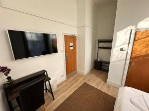 a living room with a flat screen tv on a wall at Somerset Hotel Baker Street London in London