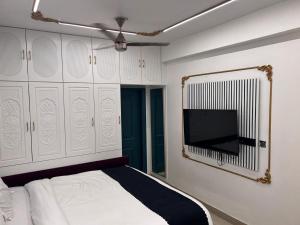 a bedroom with a bed and a flat screen tv at Roswell Nest in Gurgaon