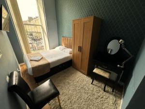 a small bedroom with a bed and a window at Somerset Hotel Baker Street London in London