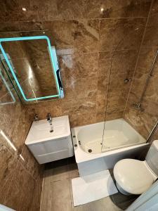 a bathroom with a sink and a tub and a toilet at Somerset Hotel Baker Street London in London
