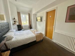 a bedroom with a large bed and a window at Somerset Hotel Baker Street London in London