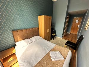 a bedroom with a bed with a wooden head board at Somerset Hotel Baker Street London in London